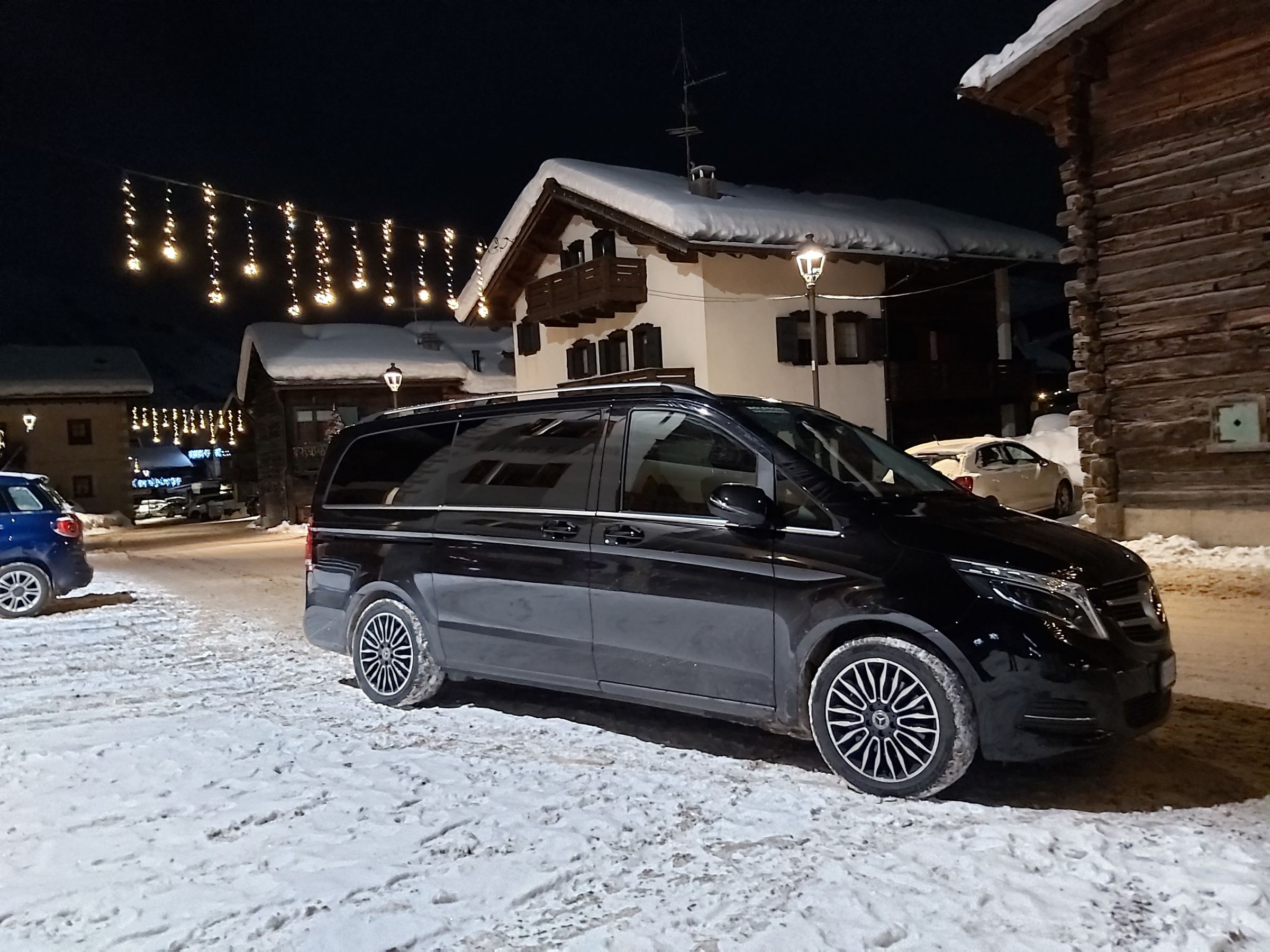 Mercedes V-250 nera di Giorgio Auto, di notte, in un paese di montagna innevato